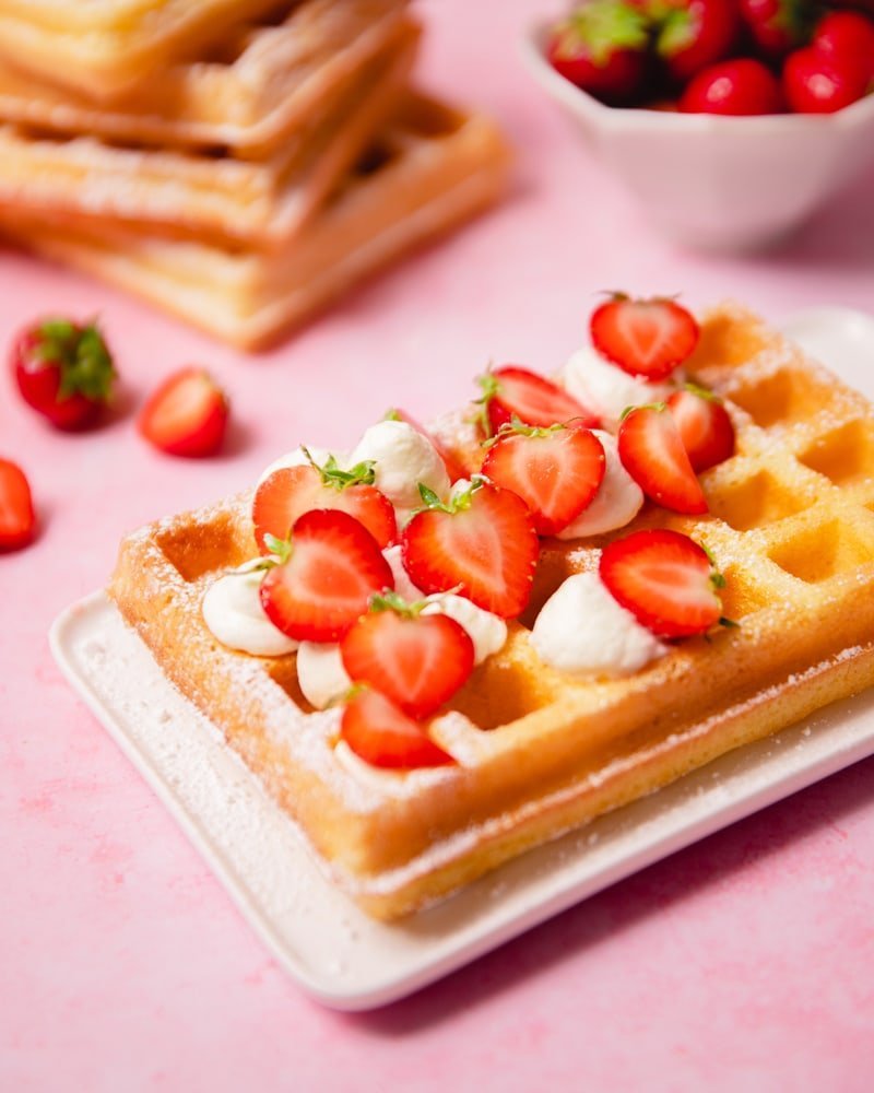 Assiette avec une gaufre de Bruxelles aux fraises et crème chantilly