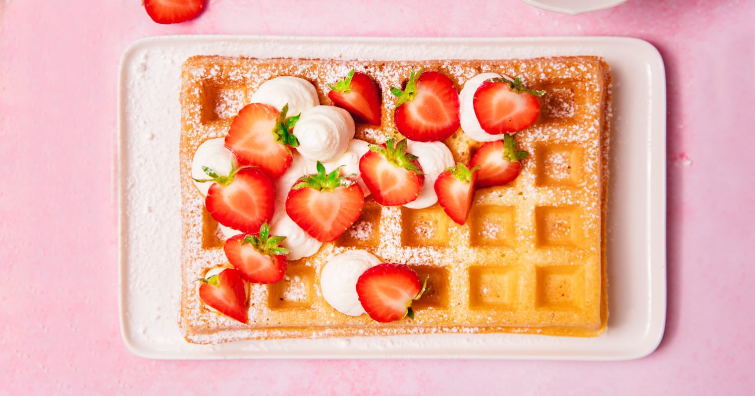 Assiette avec une gaufre de Bruxelles aux fraises et crème chantilly