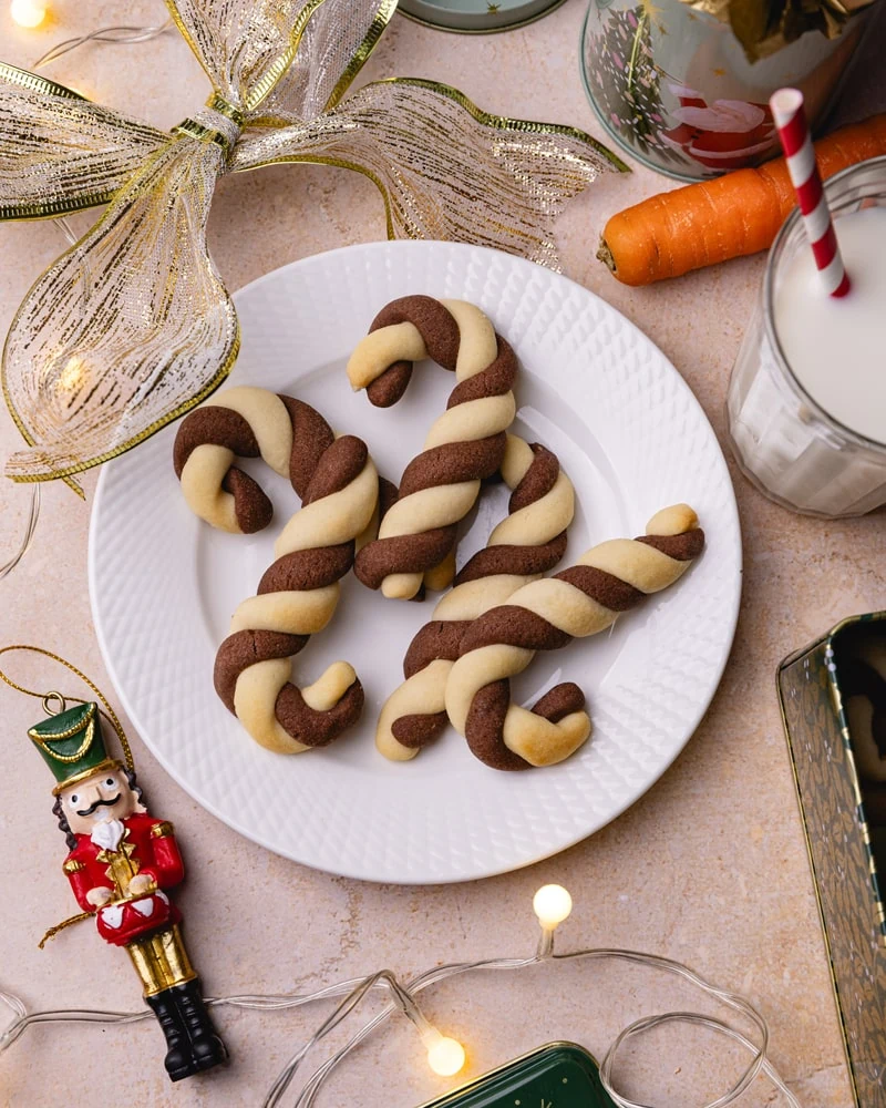 Sablés de Noël en forme de canne à sucre sur uen assiette avec du lait et une carotte pour le Père Noël