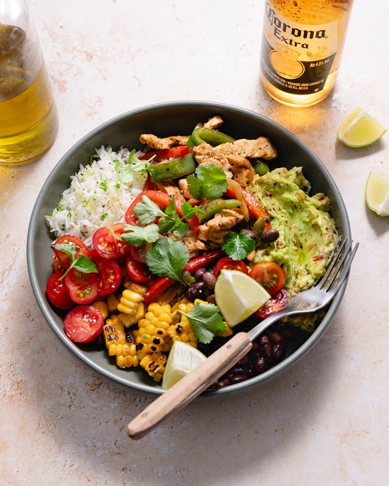 Bol de fajita poulet et poivron avec du guacamole, des tomates, des haricots noirs et du maïs