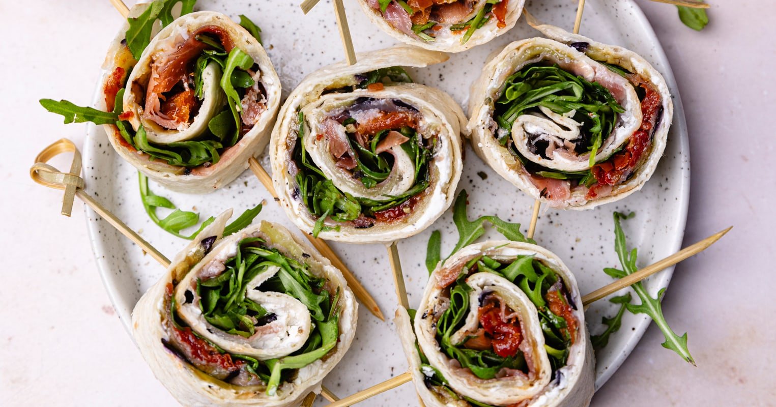 Assiette apéro, wrap à l'italienne avec du fromage blanc, du jambon cru, de l'aubergine grillée, des tomates séchées et de la roquette