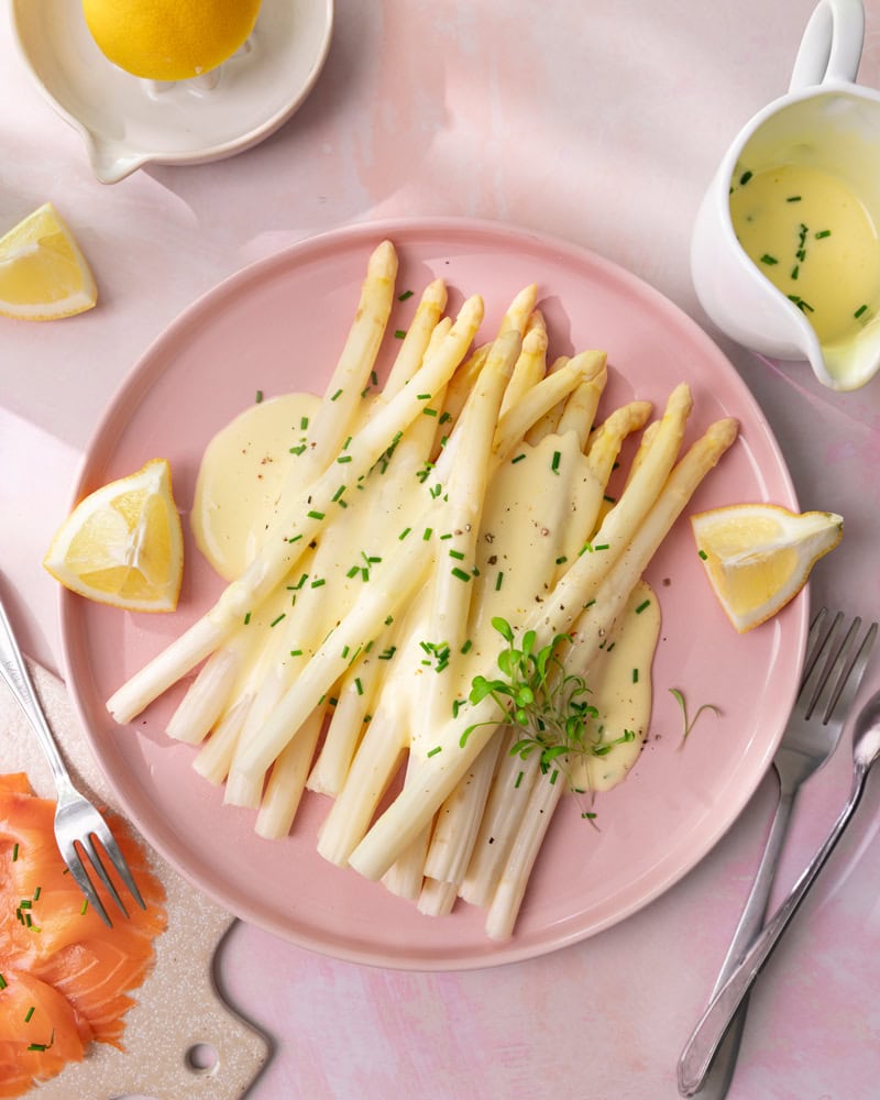 Plat d'asperges blanches sauce mousseline avec des crevettes grises