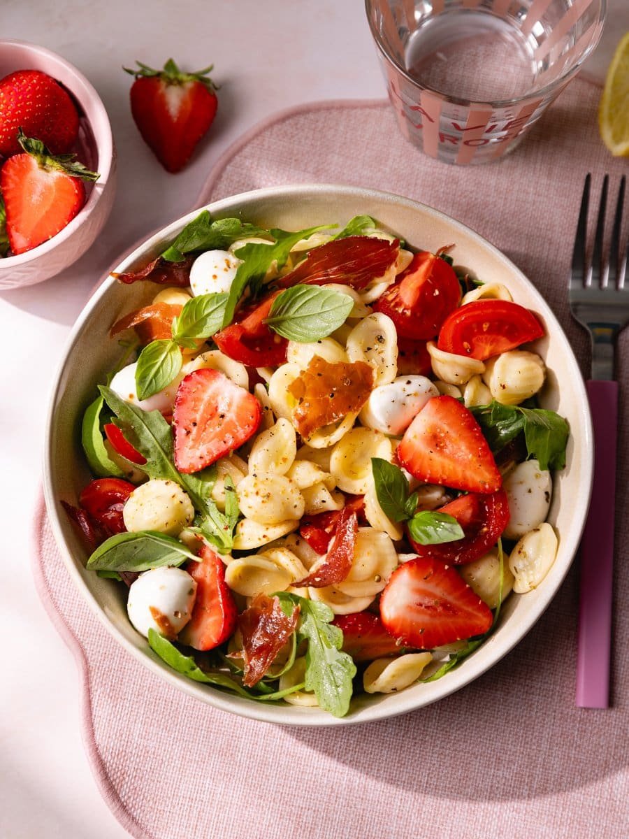 Salade de pâtes froide aux fraises, mozzarella mini billes, tomates cerises, basilic frais et jambon cru croustillant