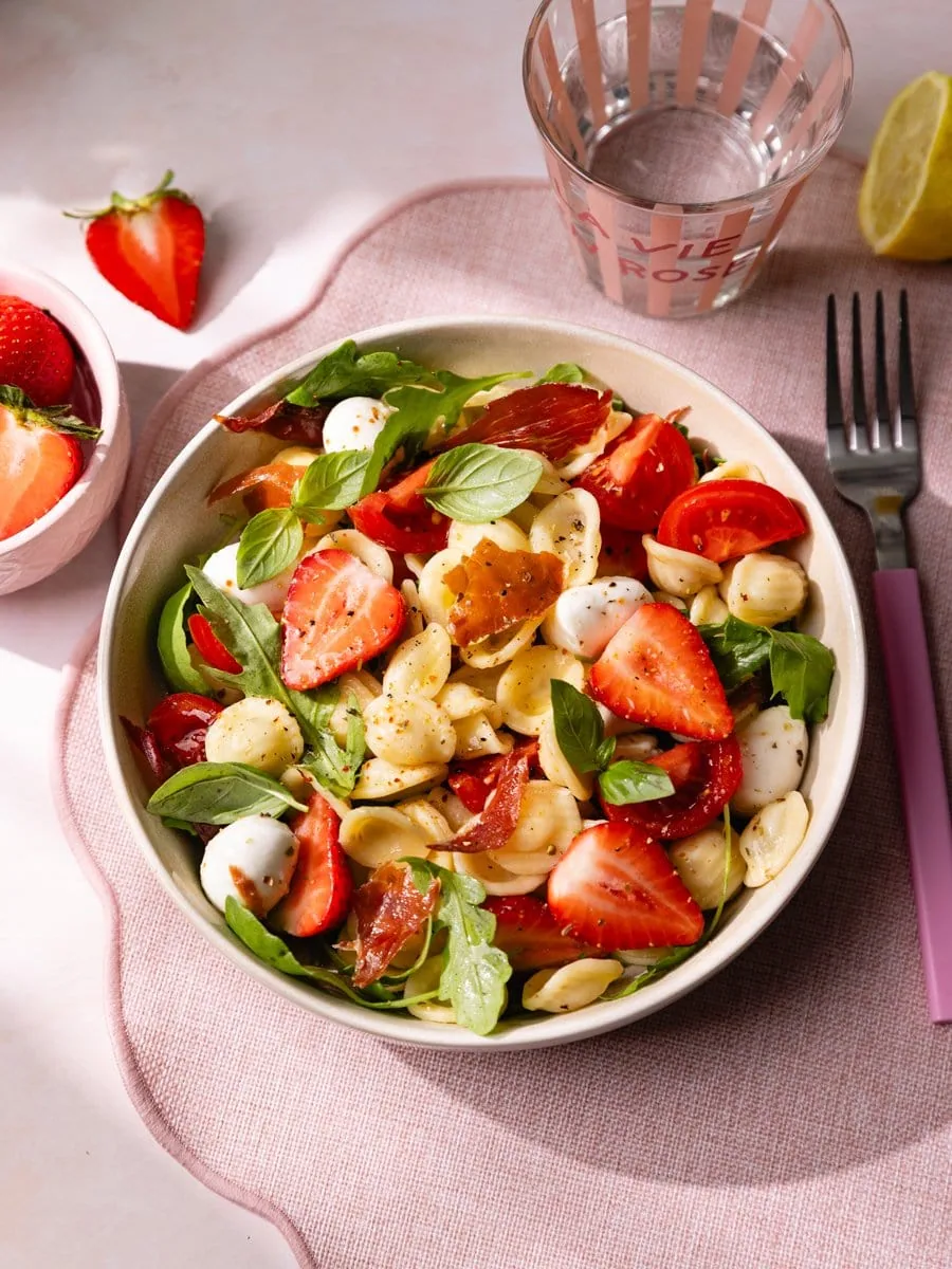 Salade de pâtes froide aux fraises, mozzarella mini billes, tomates cerises, basilic frais et jambon cru croustillant