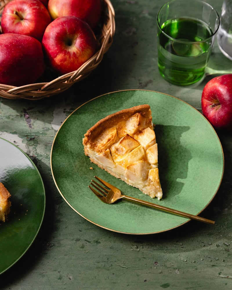 Une part de tarte normande aux pommes sur une assiette