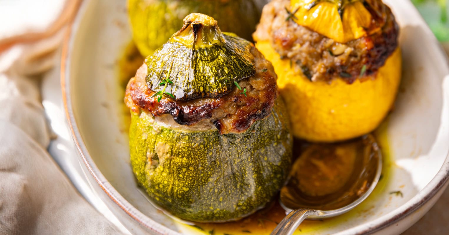 Les courgettes rondes farcies à la viande hachée dans un plat à gratin