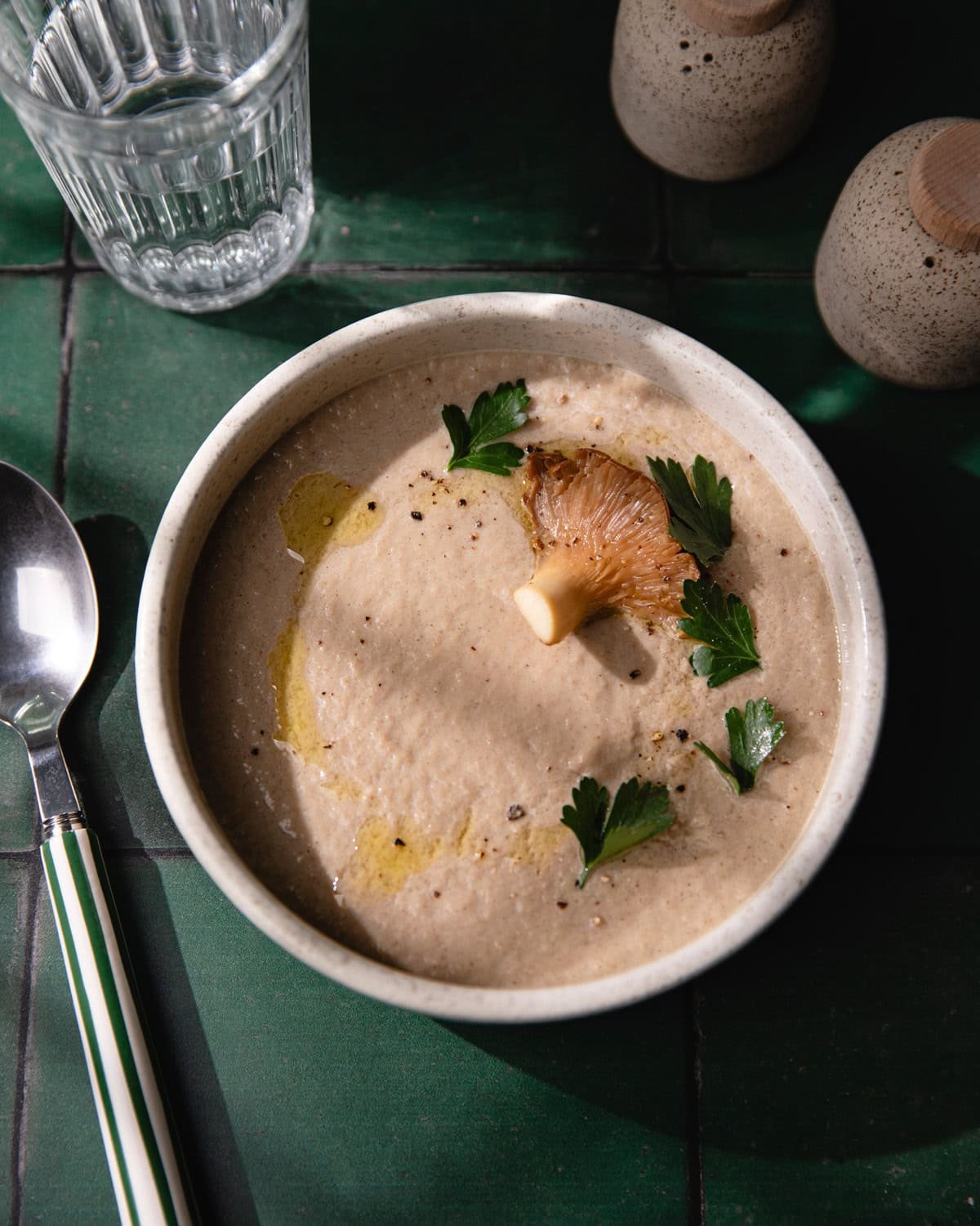 Soupe de champignons crémeuse dans un bol avec huile d'olive et persil frais.