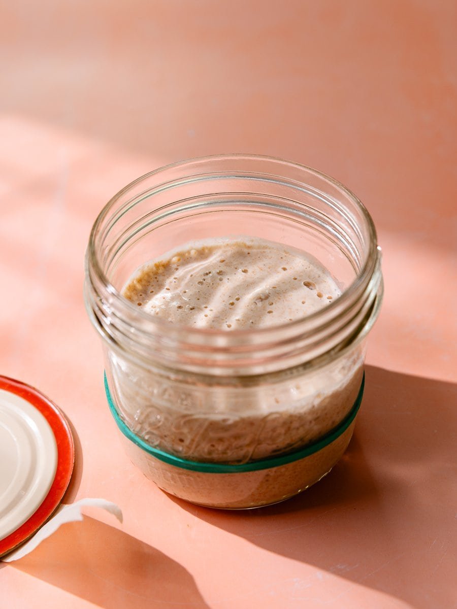 Levain de blé mature présentant une surface mousseuse et aérée dans un bocal en verre