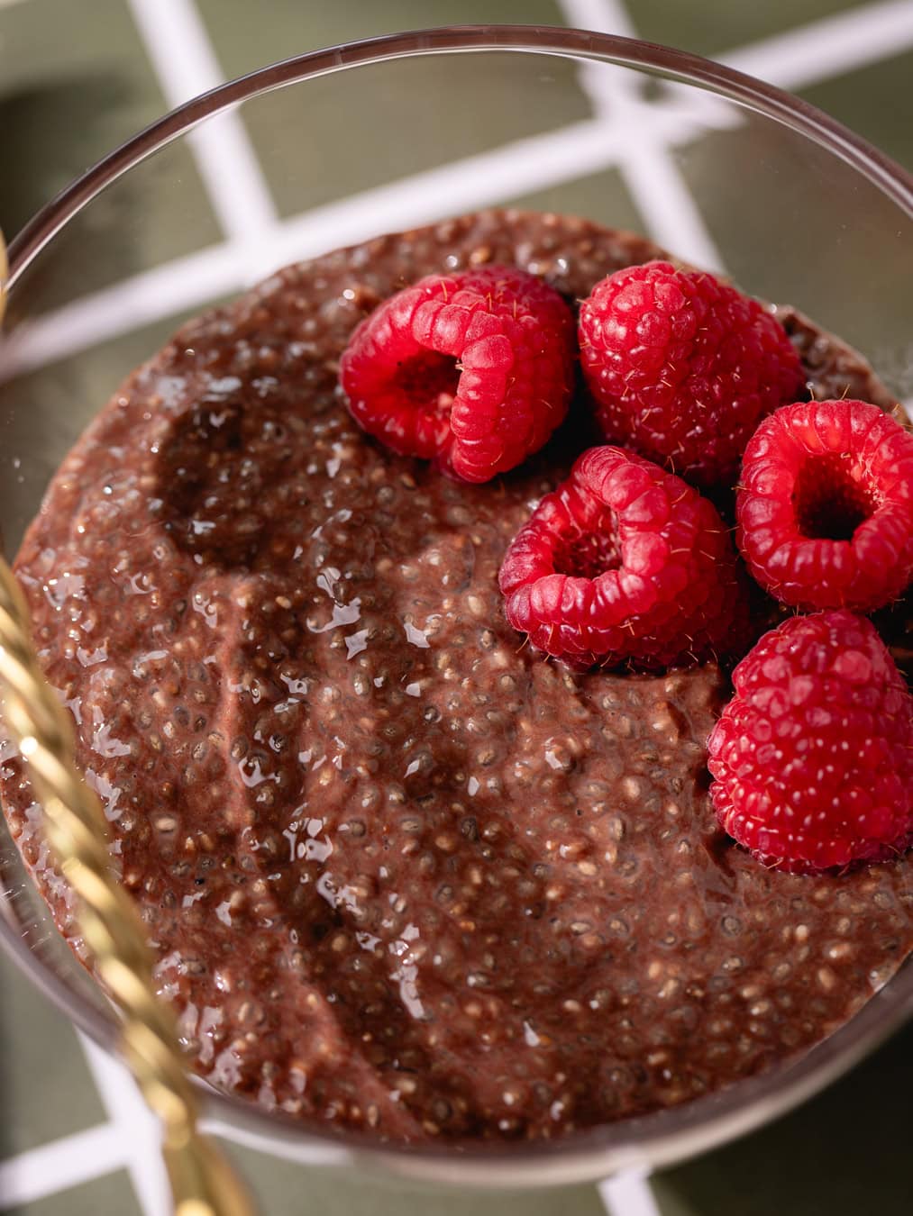 Bol de chia pudding au chocolat garni de framboises fraîches