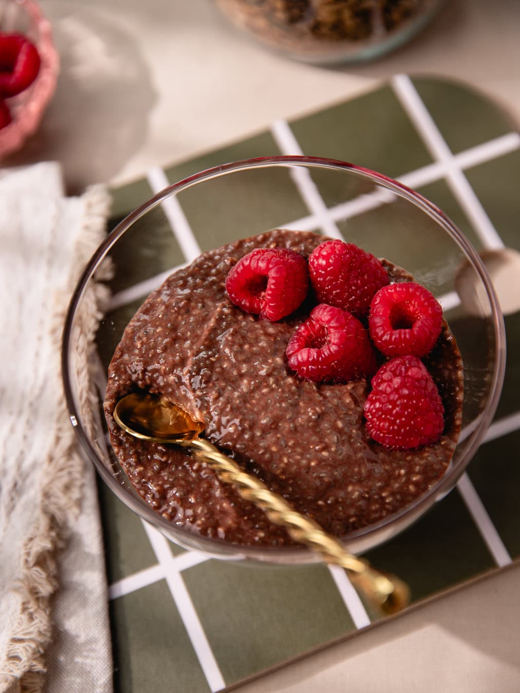 Bol de chia pudding au chocolat garni de framboises fraîches