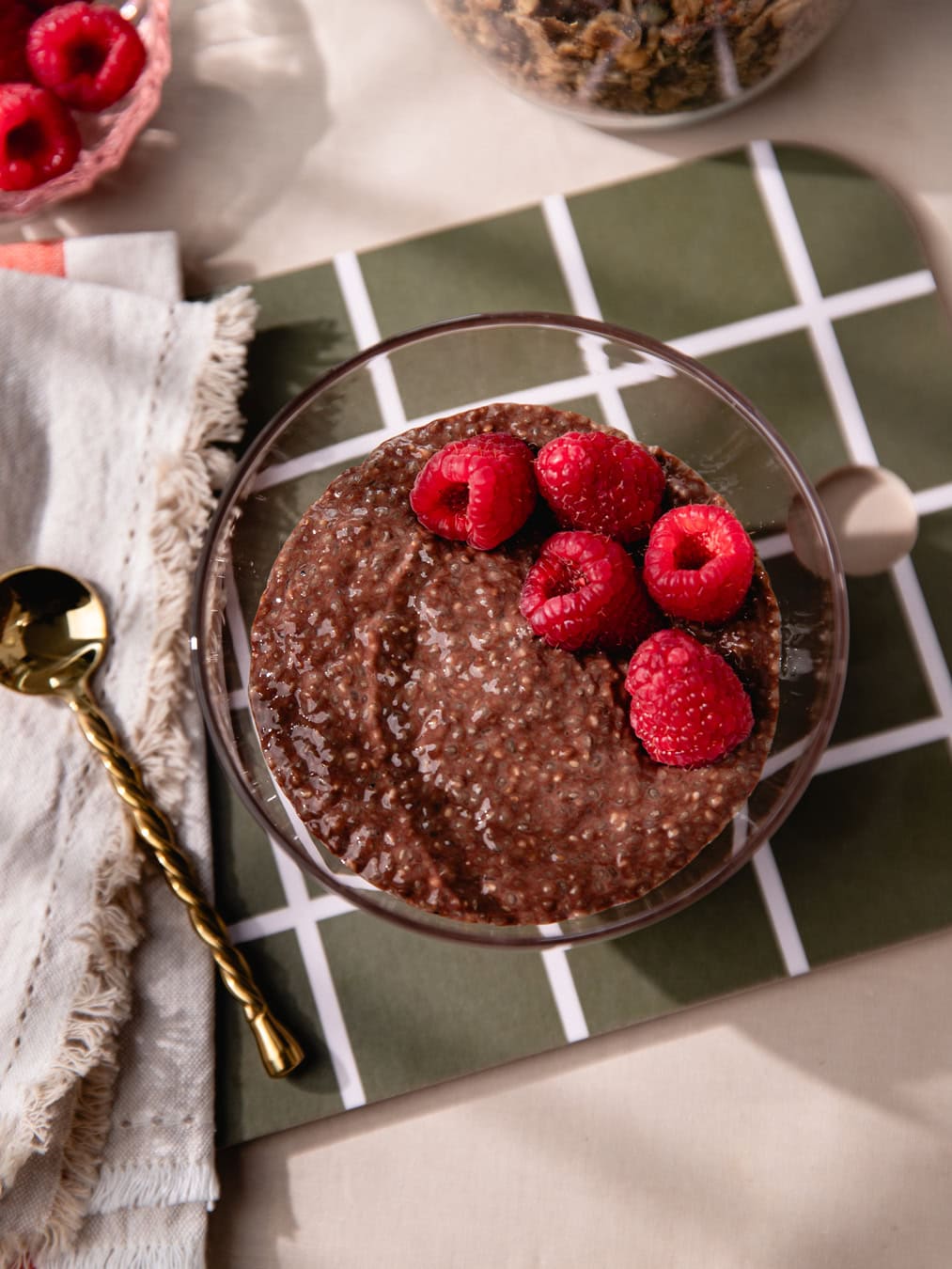 Bol de chia pudding au chocolat garni de framboises fraîches