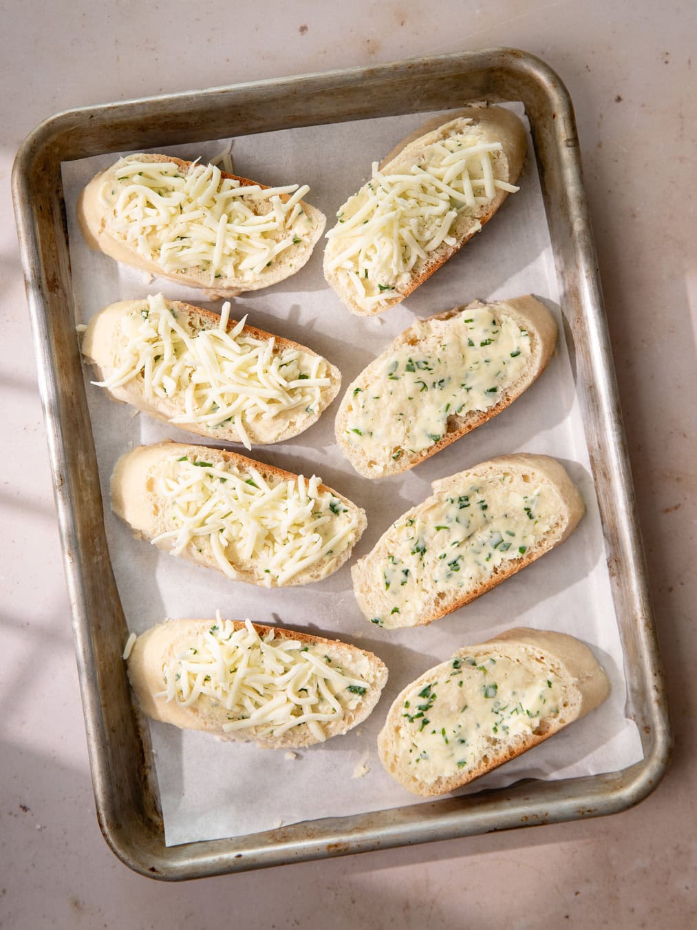 Plaque de four avec des pains à l'ail (avant cuisson)