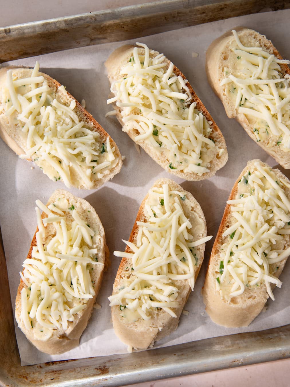 Plaque de four avec des pains à l'ail (avant cuisson)