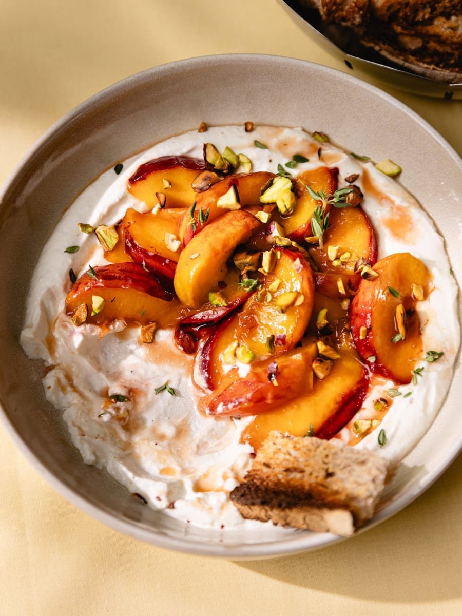 Assiette de cottage cheese fouetté avec pêches caramélisées, pistaches et thym