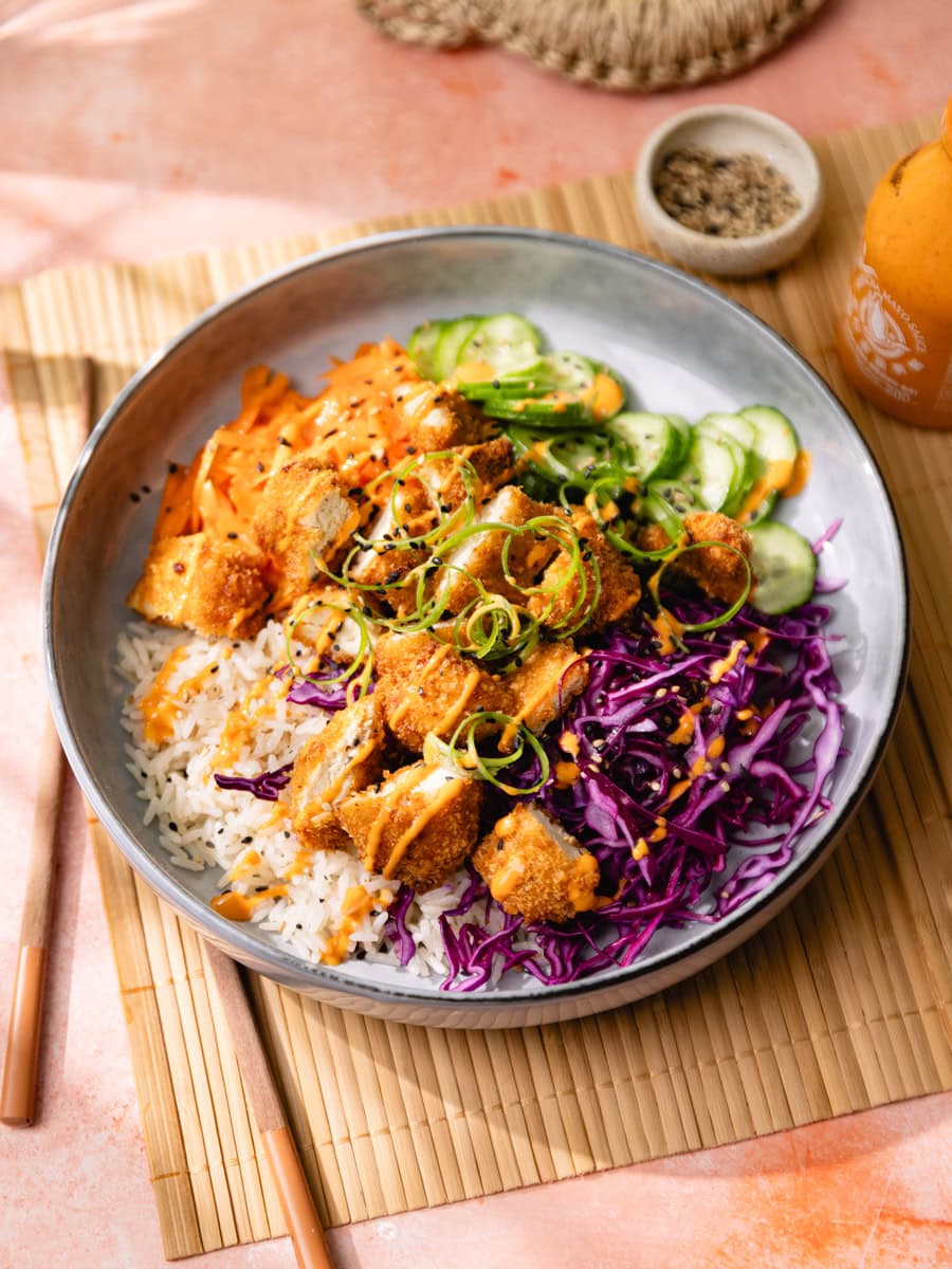 Bol de donburi de poulet crispy, légumes croquants et sauce sriracha