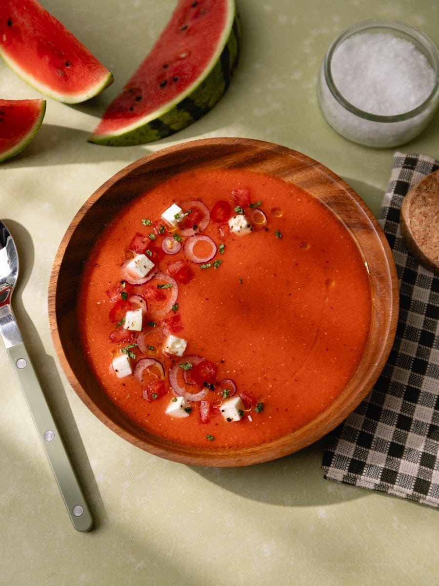 Bol de gaspacho à la pastèque et tomates avec quartiers de pastèque sur la table