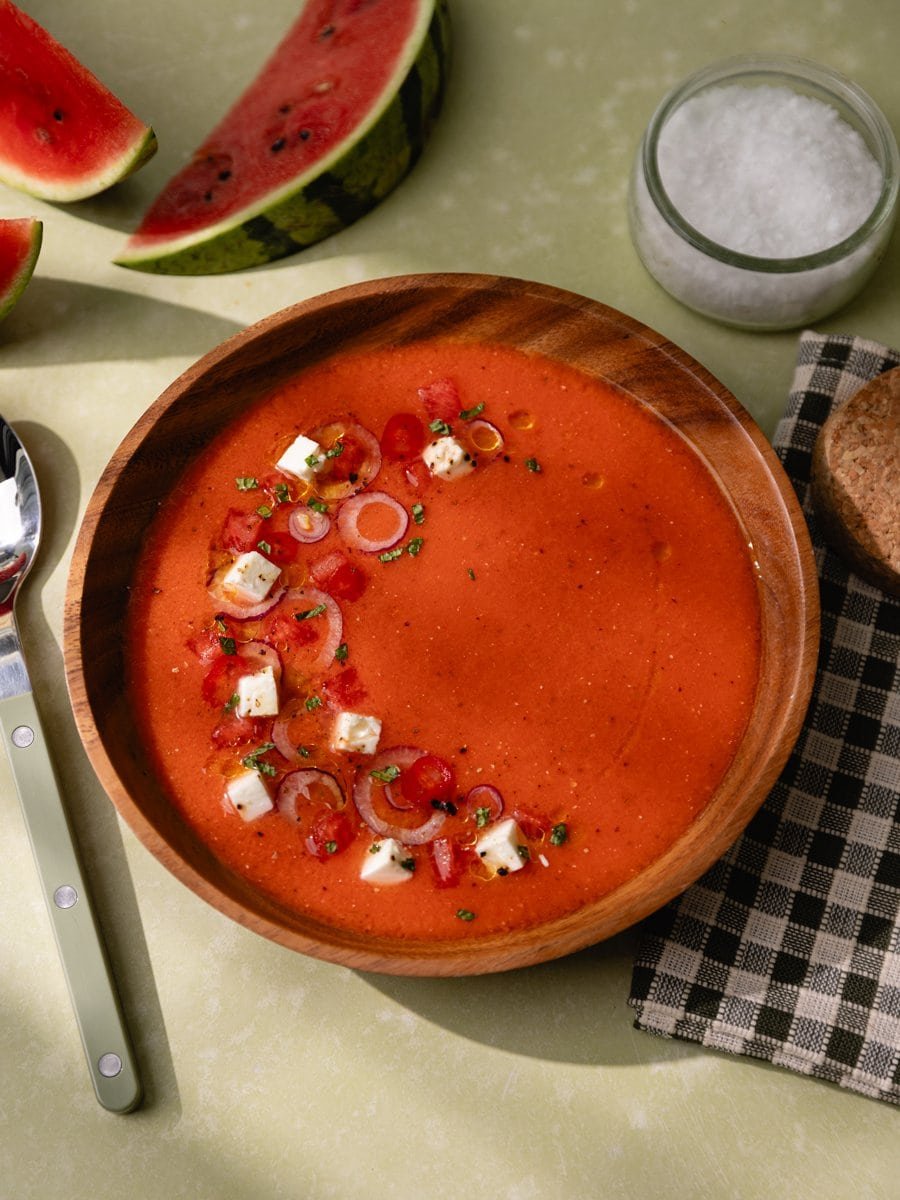 Bol de gaspacho à la pastèque et tomates avec quartiers de pastèque sur la table