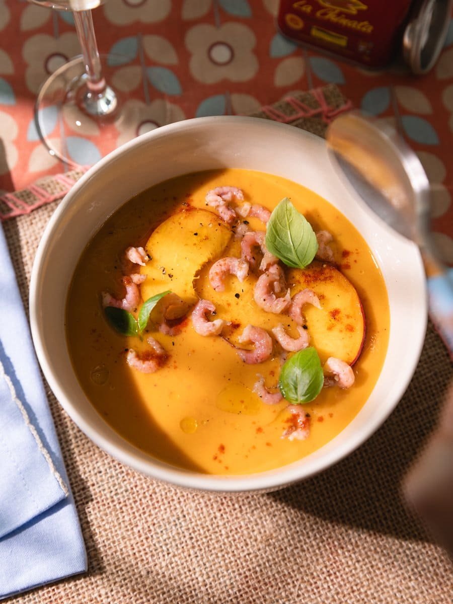 Bol de gaspacho de pêches avec crevettes grises vu du dessus