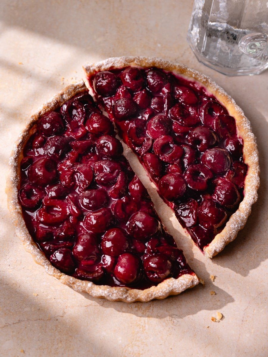 Tarte aux cerises sur pâte levée avec une part retirée