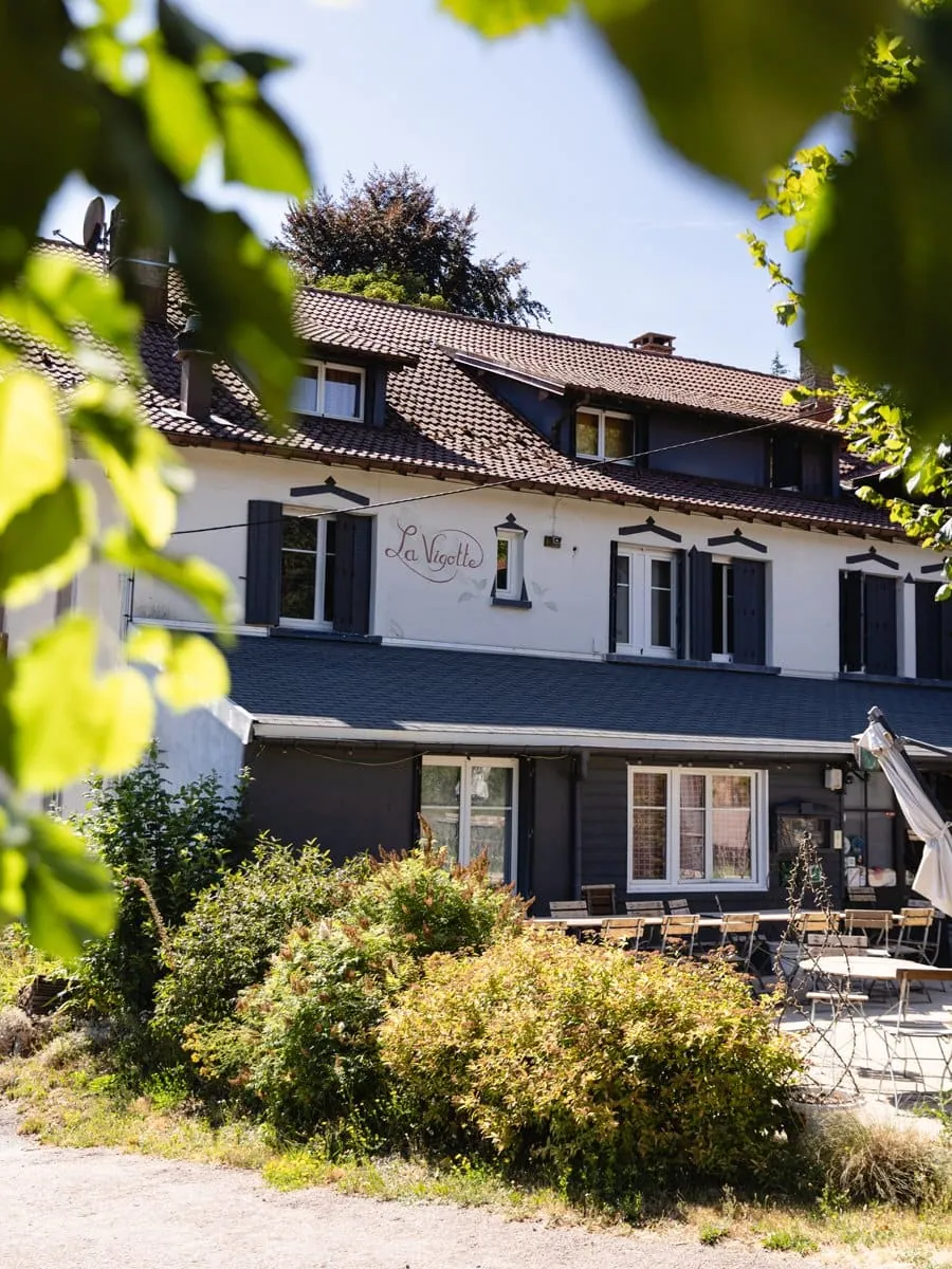 Façade de l'hôtel-restaurant La Vigotte entourée de végétation